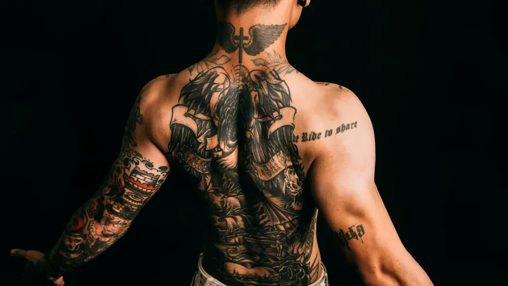 A full back piece tattoo with sleeves on both arms